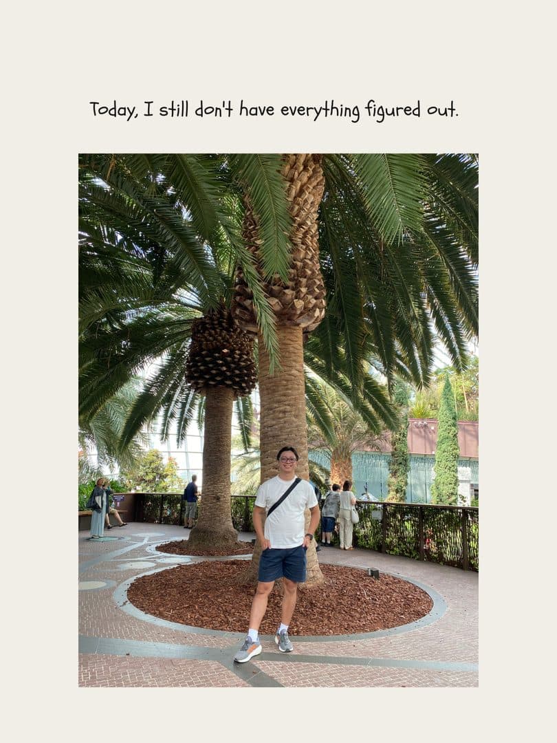Godfrey standing under palm trees at a conservatory